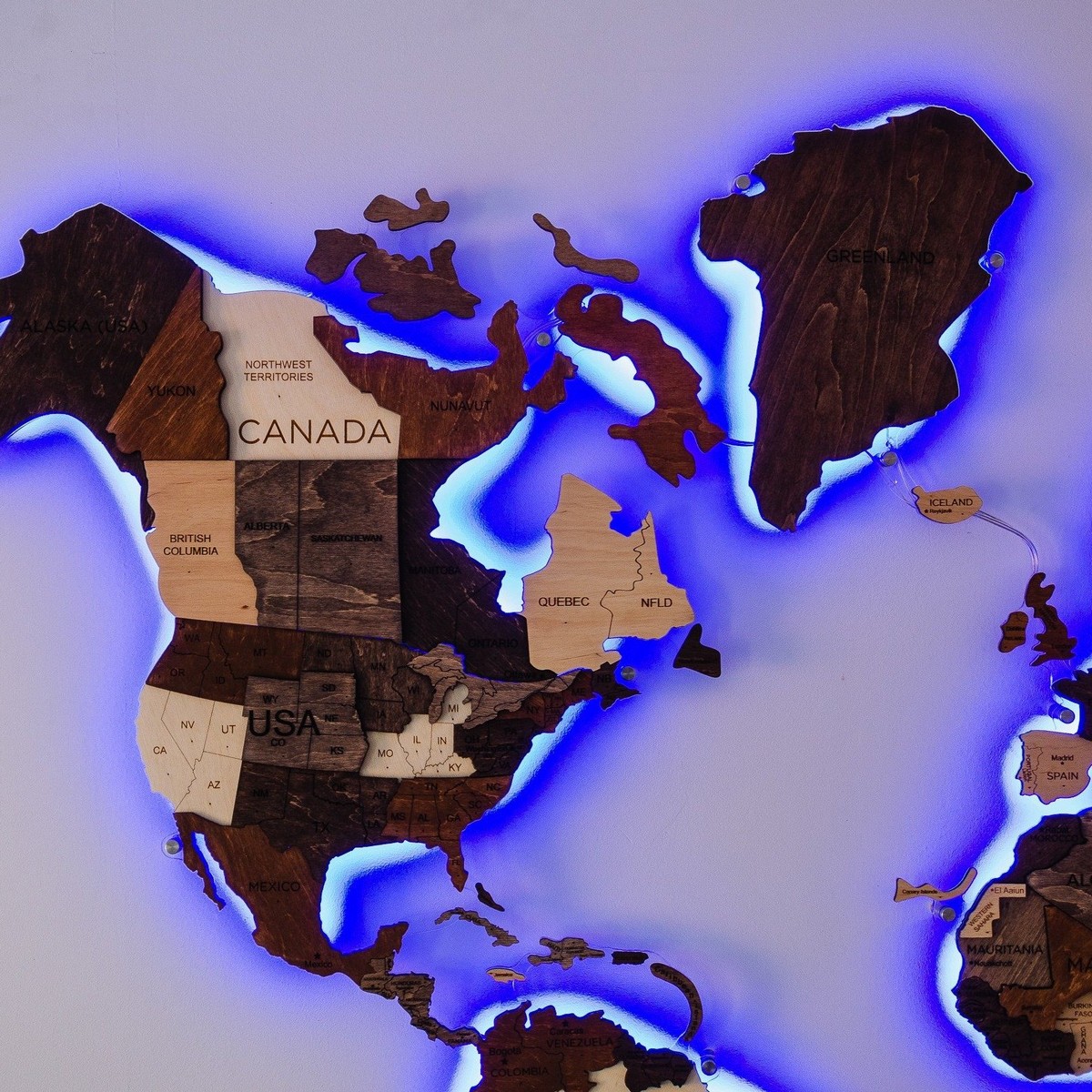 Harta e botës prej druri me dritë prapa në një mur